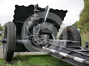 German cannon during the second world war on a cloudy summer day painted in black camouflage.