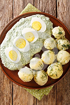 German cuisine boiled potatoes with eggs frankfurt green sauce close-up. vertical top view