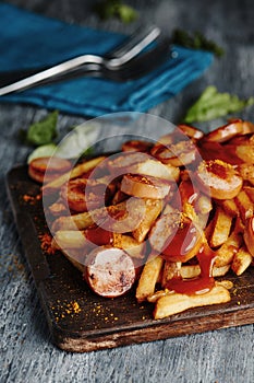 german currywurst and chips on a chopping board
