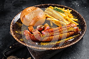 German currywurst sausage, curry wurst served with French fries. Dark background. Top view