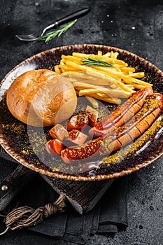 German currywurst sausage, curry wurst served with French fries. Dark background. Top view