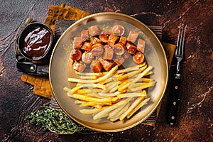 German currywurst sausage, curry wurst served with French fries. Dark background. Top view