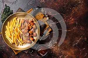 German currywurst sausage, curry wurst served with French fries. Dark background. Top view. Copy space