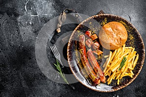 German currywurst sausage, curry wurst served with French fries. Dark background. Top view. Copy space