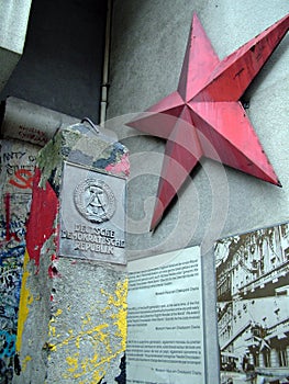 German Democratic Republic sign and red star, Column and Berlin wall portion near Checkpoint Charlie between east and west sectors