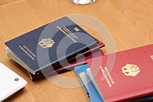 German diplomatic passport and others on a wooden table, close-up. Border crossing, travel, immigration concept photo