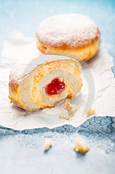 German donuts - berliner filled with strawberry jam with icing sugar