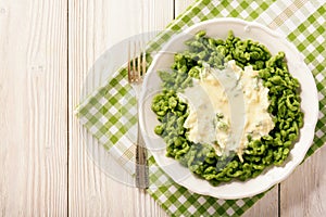 German dumplings spaetzle with spinach and cheese sauce. photo