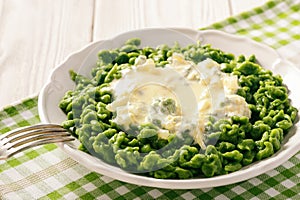 German dumplings spaetzle with spinach and cheese sauce. photo