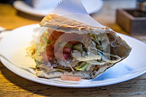 German DÃ¶ner Kebab in pita flatbread with salad and chicken meat on plate