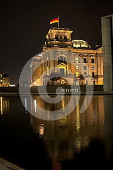 German federal parliament with a german flag and a reflection in the water in the river spree