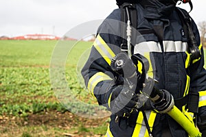 German Firefighter with water hose in action