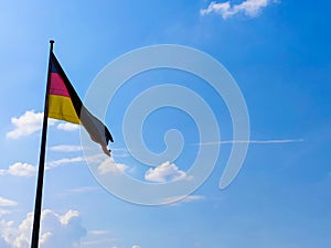 German flag. Against the background of blue sky