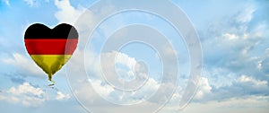 German flag on balloon against sky clouds background. Education, charity, emigration, travel and learning German language, Germany