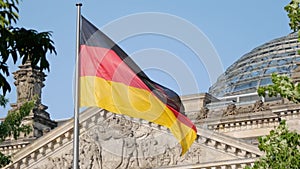 German flag in front of the Reichstag in Berlin, Germany fluttering in the wind