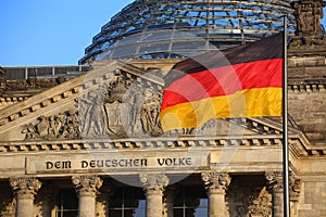 The German flag in front of the Reichstag building in Berlin. The inscription says: Dem Deutschen Volke - To the German people