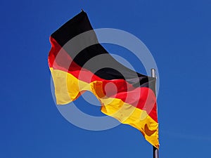 German Flag in gusty wind conditions under a blue sky