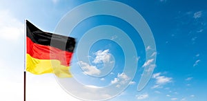 German flag waving against blue sky