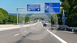 German highway with visible cars, signs and exits. Motorway without speed limit.