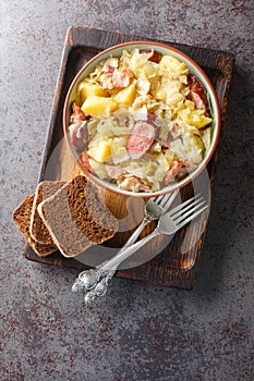 German Jager Kohl, hunter\'s cabbage with Sausage, Bacon and Potatoes close-up in a bowl. Vertical top view