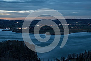 German lake `Kochelsee` with lights in the sunset