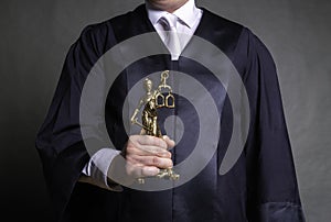 german lawyer with a robe holding a statue of Lady Justice