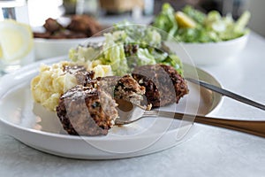 German meatballs with mashed potatoes and salad on a dinner table