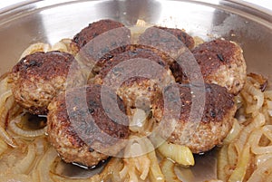 German meatballs sizzling in pan