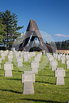 German military cemetery in autumn with mountains in the background and many graves of soldiers killed in the Second World War.