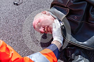 German paramedic check blood pressure on an injured biker