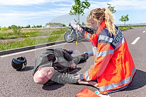 German paramedic helps an injured motorcyclist