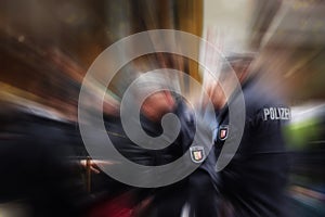 German police officers in action, focus on the POLIZEI emblem on photo