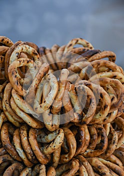 German pretzels stack one over each other, group of thin dry pretzels on rope on display