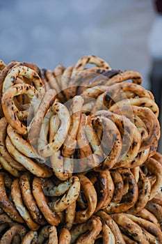 German pretzels stack one over each other, group of thin dry pretzels on rope on display