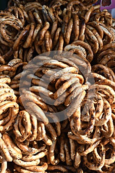 German pretzels stack one over each other, group of thin dry pretzels on rope