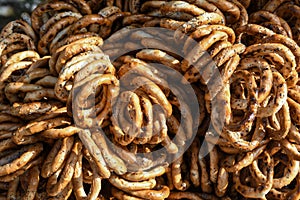 German pretzels stack one over each other, group of thin dry pretzels on rope