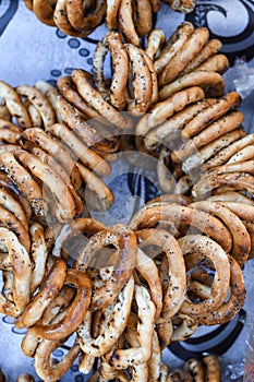 German pretzels stack one over each other, group of thin dry pretzels on rope