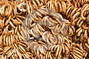 German pretzels stack one over each other, group of thin dry pretzels on rope