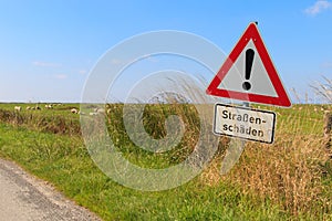 German road sign warning of road damage