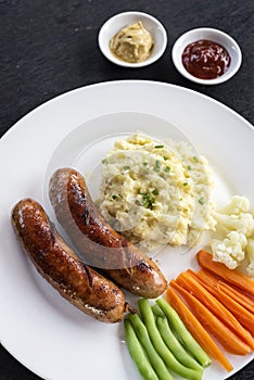 German sausage with mashed potato and vegetables meal