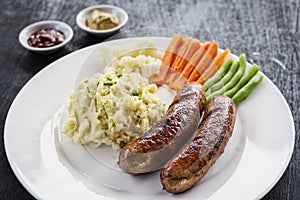 German sausage with mashed potato and vegetables meal