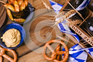 German sausages on the grill. Traditional and pastry brezel for the beer festival. Wood background and decor. View from