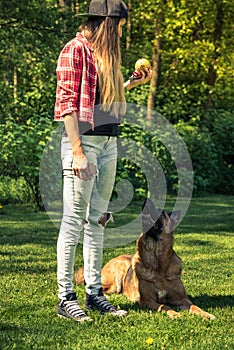 German shepherd obedience training by woman in garden