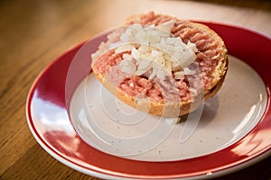 German snack buns with raw minced pork meat, pepper and onions  on bread bun roll