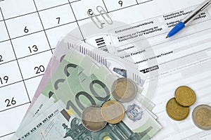 German tax form with pen and european money bills lies on office calendar. Taxpayers in Germany using euro currency to pay taxes