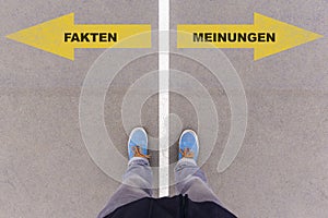 German text Fakten and Meinungen on asphalt ground, feet and shoes on floor
