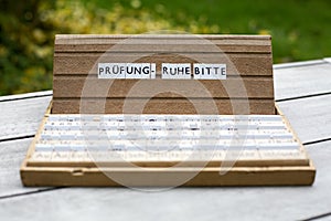 German text: Pruefung Ruhe bitte