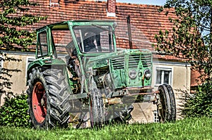 German vintage tractor stands on a green meadow