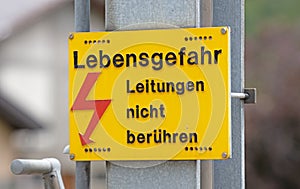 German warning sign `Don`t touch high voltage power lines, danger to life` german: `Hochspannung, Leitungen nicht beruhren