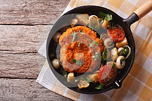 German Weiner schnitzel with vegetables in a pan. horizontal top